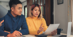 un jeune couple consultant des documents portant sur leur cote de crédit suite à une proposition de consommateur